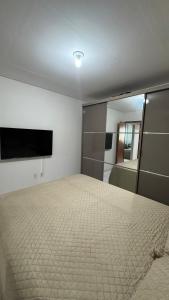 a bedroom with a bed and a large mirror at 1- Apartamento aconchegante 1200m do Centro in Serra Talhada