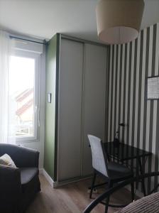 a living room with a table and a chair at Eugenie86 chbre2 in Poitiers
