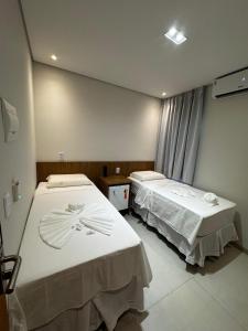 ein Zimmer mit zwei Betten in einem Zimmer in der Unterkunft Mairí Hotel in Itaituba