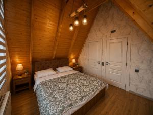 a bedroom with a bed in a room with wooden walls at Gabala Twin Chalet in Gabala