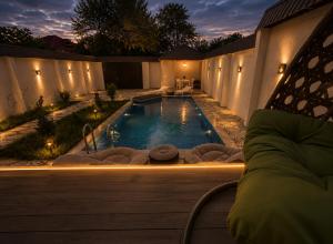a swimming pool in a backyard at night at Gabala Twin Chalet in Gabala