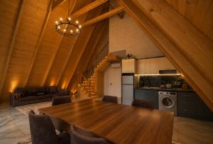 a kitchen and dining room with a wooden table and chairs at Gabala Twin Chalet in Gabala