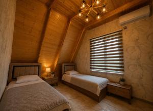 a bedroom with two beds and a window at Gabala Twin Chalet in Gabala