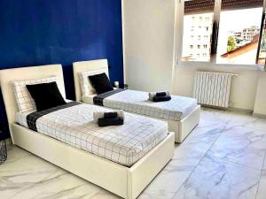 two beds are in a room with blue walls at Gran Premio Monza - Autodromo con Wi-Fi e aria condizionata in Monza +14 photos