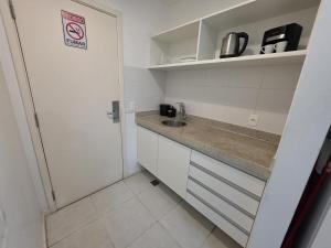 a small kitchen with a sink and a no smoking sign at Flat perto da Esplanada | SHN in Brasília