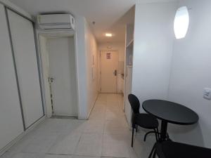 a room with a table and chairs and a hallway at Flat perto da Esplanada | SHN in Brasília