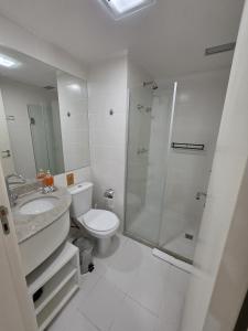 a bathroom with a shower and a toilet and a sink at Flat perto da Esplanada | SHN in Brasília +9 photos