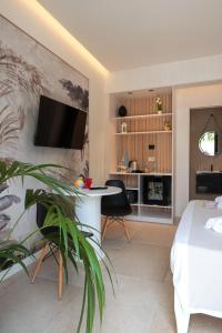 a bedroom with a bed and a desk with a tv on a wall at Sunset Beach Club Tropea in Tropea