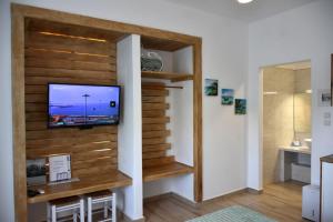 a living room with a tv on a wooden wall at Soultana’s house in Mourteri