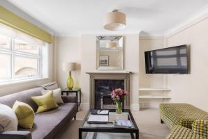 a living room with a couch and a fireplace at Beaufort House - Knightsbridge in London