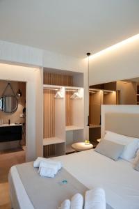 a bedroom with a large white bed with white pillows at Sunset Beach Club Tropea in Tropea