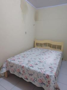 a bedroom with a bed with a floral bedspread at Casa de Lagoa Nova in Martins +4 photos