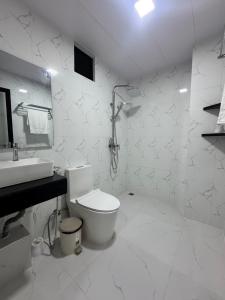 a white bathroom with a toilet and a sink at Rindhali Thoddoo in Thoddoo +21 photos