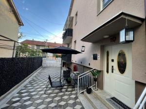 a patio with an umbrella next to a building at Tina apartman in Vranje