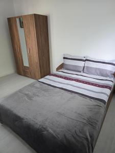 a bed in a bedroom with a wooden cabinet at Вила Стоянови in Yasen