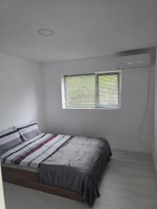 a bedroom with a bed and two windows at Вила Стоянови in Yasen