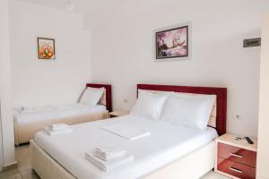 two beds in a room with white walls at Vila Finnley in Ksamil +93 photos