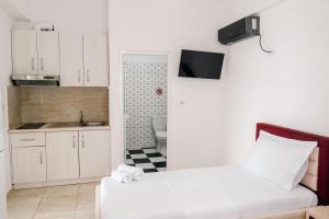 a small white kitchen with a bed and a sink at Vila Finnley in Ksamil