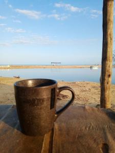a coffee cup sitting on a table near the beach at Kaigeemayapo in Manaure