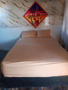a bed in a room with a kite on the wall at Kaigeemayapo in Manaure