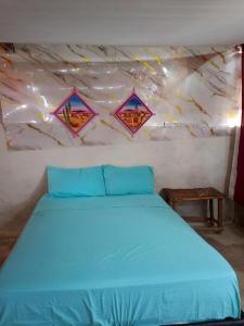 a bedroom with a blue bed with kites on the wall at Kaigeemayapo in Manaure