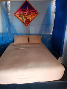 a bed in a tent with a picture on the wall at Kaigeemayapo in Manaure +5 photos