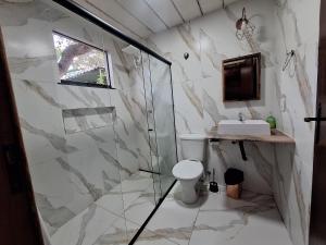 a bathroom with a shower and a toilet and a sink at Chalé da lagoa in Lagoa Santa +34 photos