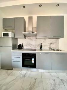 a white kitchen with white cabinets and a sink at Gran Premio Monza - Autodromo con Wi-Fi e aria condizionata in Monza