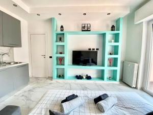 a living room with a television and blue shelves at Gran Premio Monza - Autodromo con Wi-Fi e aria condizionata in Monza