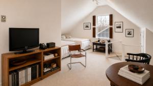 a living room with a television and a bed at 29 India House in Nantucket