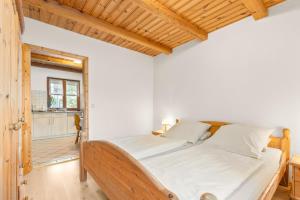 a bedroom with a bed and a wooden ceiling at Mayerbauer in Piding