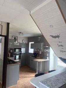a kitchen with a sink and a table in a room at Gîte de L'embarcadère in Moustéru +2 photos