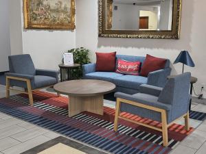 a living room with a couch and two chairs and a table at Grander Inn & Suites by IHG in Tyler +51 photos