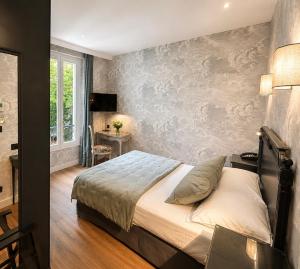 a bedroom with a bed and a table and a window at Hotel des Bains in Paris