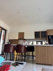 a woman sitting at a counter in a kitchen at Cuchi Downtown in Xóm Bến Cỏ