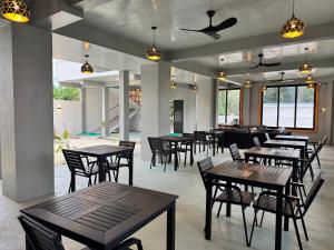 a restaurant with wooden tables and chairs in a room at Rindhali Thoddoo in Thoddoo