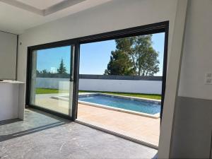 a sliding glass door in a house with a swimming pool at IROC Private Garden in Quinta do Anjo