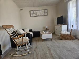 a living room with a chair and a couch at Ici et nulle part ailleurs in Saint-Vivien-de-Médoc