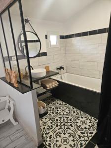 a bathroom with a tub and a sink and a bath tub at Ici et nulle part ailleurs in Saint-Vivien-de-Médoc +12 photos