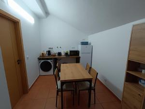 a kitchen with a table and a table and chairs at Casinha do Rui in Sines