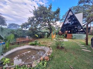 a garden with a pond in front of a building at Chalé da lagoa in Lagoa Santa