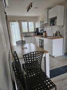 a kitchen with a wooden table and chairs in it at Ici et nulle part ailleurs in Saint-Vivien-de-Médoc