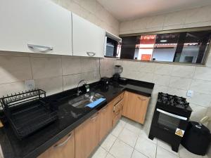 a kitchen with a sink and a stove at Casa da Dinda 104 in Rio das Ostras
