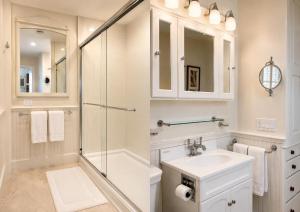 a white bathroom with a shower and a sink at 29 India House in Nantucket +29 photos