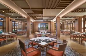 a dining room with tables and chairs and windows at Amari Vogue Krabi in Tab Kaek Beach