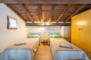 a room with two beds and a table at Mury by DomusAway in Porto Istana