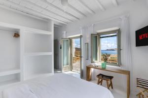 a bedroom with a bed and a view of the ocean at Villa Evita Panormos private pool & jacouzzi in Mykonos +48 photos