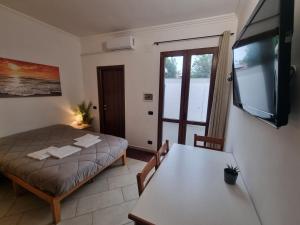 a room with a bed and a table and a television at Red Rose Tiburtina in Rome