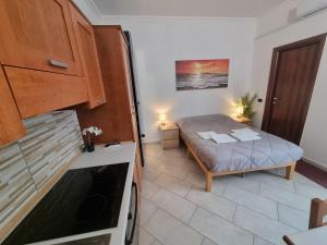 a small kitchen with a bed and a refrigerator at Red Rose Tiburtina in Rome