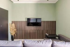 a living room with a couch and a tv on a wall at Walk to Fly Gate 65 Appartaments in Naples